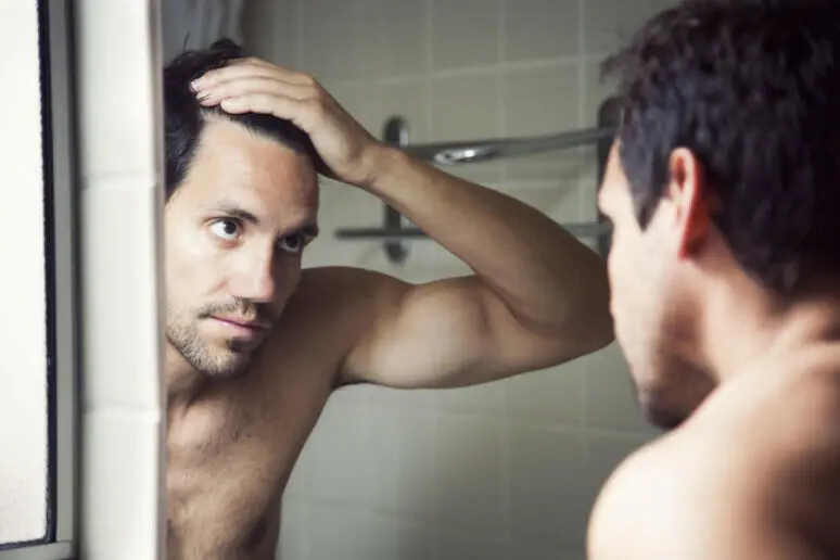 uomo che si guarda allo specchio
