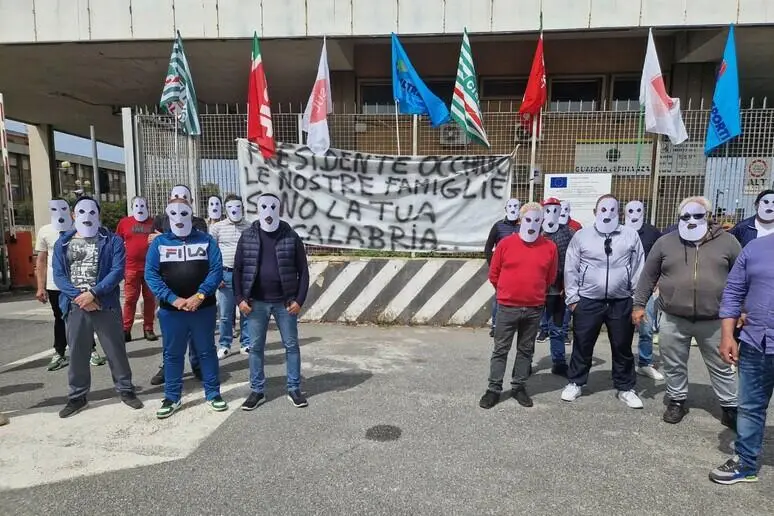 Lavoratori in protesta con maschere