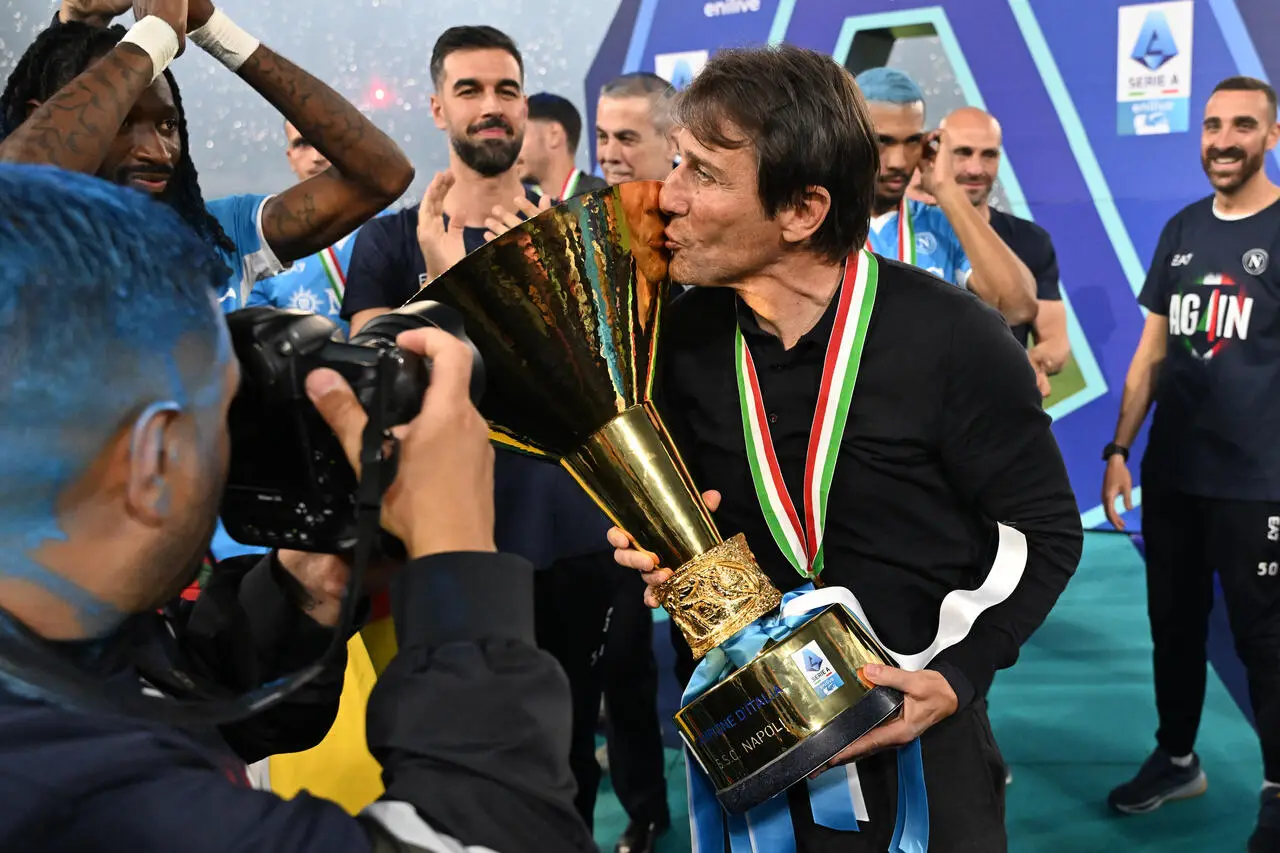 NAPLES, ITALY - MAY 23: Antonio Conte, Head Coach of Napoli, kisses the Serie A TIM Scudetto title trophy after his team's victory in the Serie A match between Napoli and Cagliari at Stadio Diego Armando Maradona