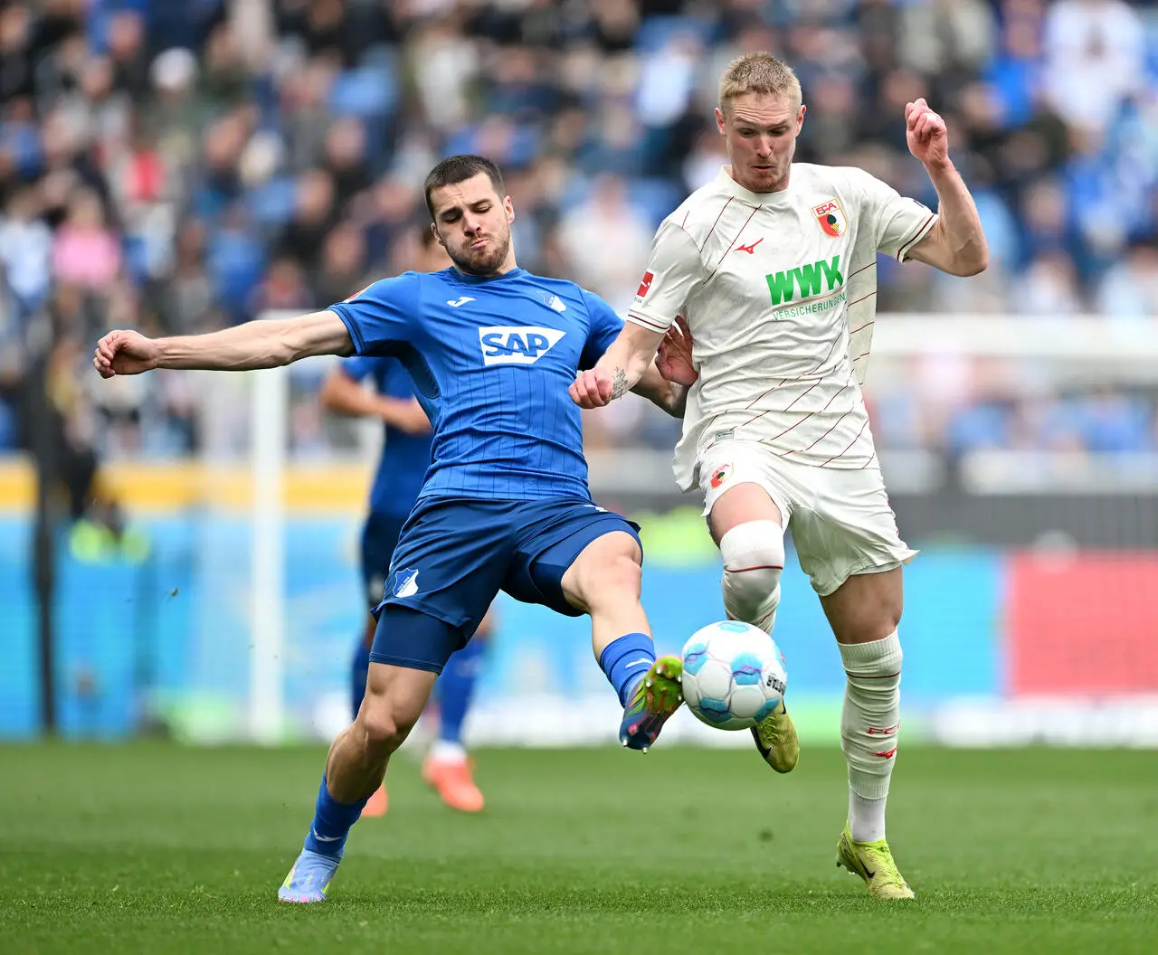 Jensen of FC Augsburg is challenged by David Jurasek of TSG 1899 Hoffenheim during the Bundesliga match between TSG 1899 Hoffenheim and FC Augsburg at PreZero-Arena on March 29, 2025 in Sinsheim, Germany.