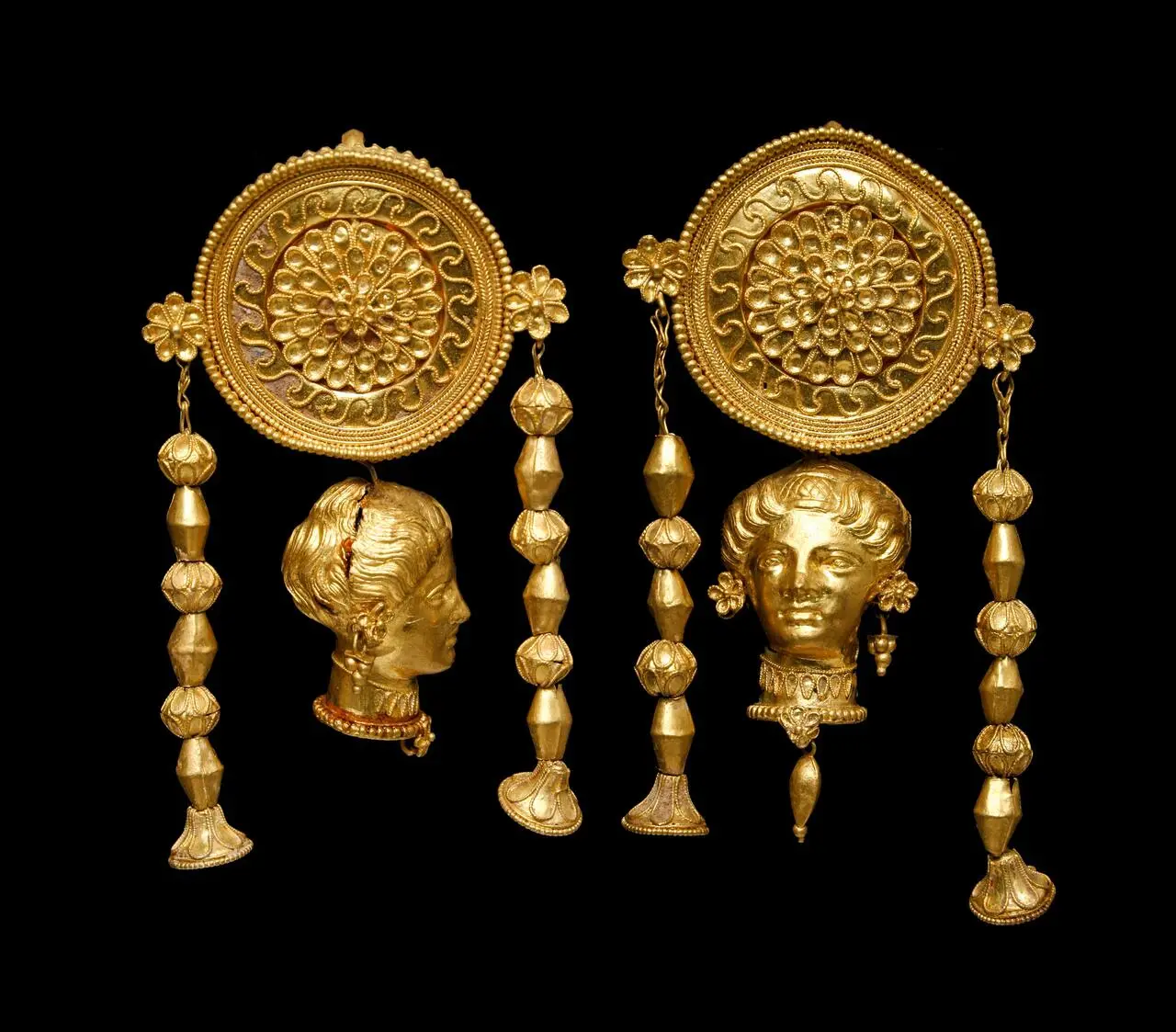 Orecchini a disco con testa femminile tomba di Crispiano - IV sec aC MArTA