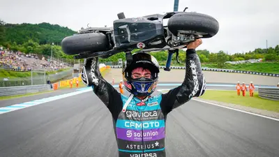 David Alonso che alza al cielo la sua prima minimoto mentre festeggia il titolo di Moto3