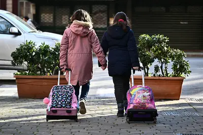 Bambine trasportano trolley mano nella mano