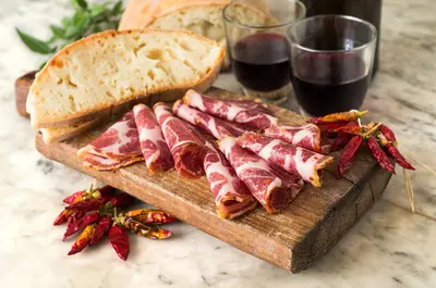 Pane, capocollo, peperoncino, vino e tagliere