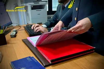 Finanzieri che scrivono al computer e guardano fascicolo