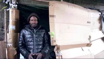 Sidy nella sua baracca, costruita con cartoni.