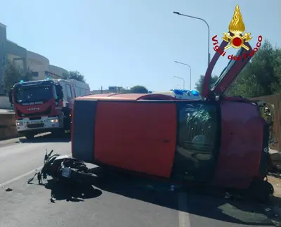 auto ribaltata e scooter a terra