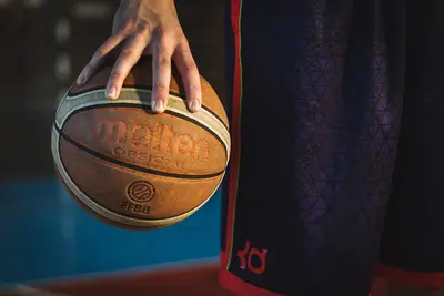 persona palleggia con palla da basket