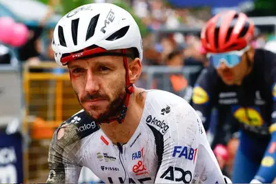 Il britannico Adam Yates, coperto di sangue, taglia il traguardo della seconda tappa del Giro 2026. ©LUCA BETTINI / AFP
