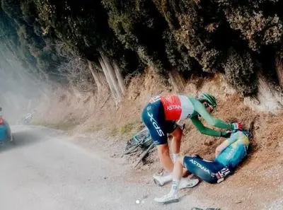 Alberto Bettiol soccorre Christian Scaroni durante la Strade Bianche © Christian Scaroni via X