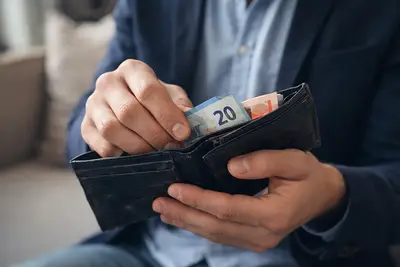 una mano conta i soldi nel portafoglio